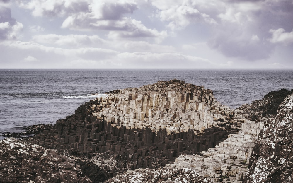 brown rock formation near body of water during daytime