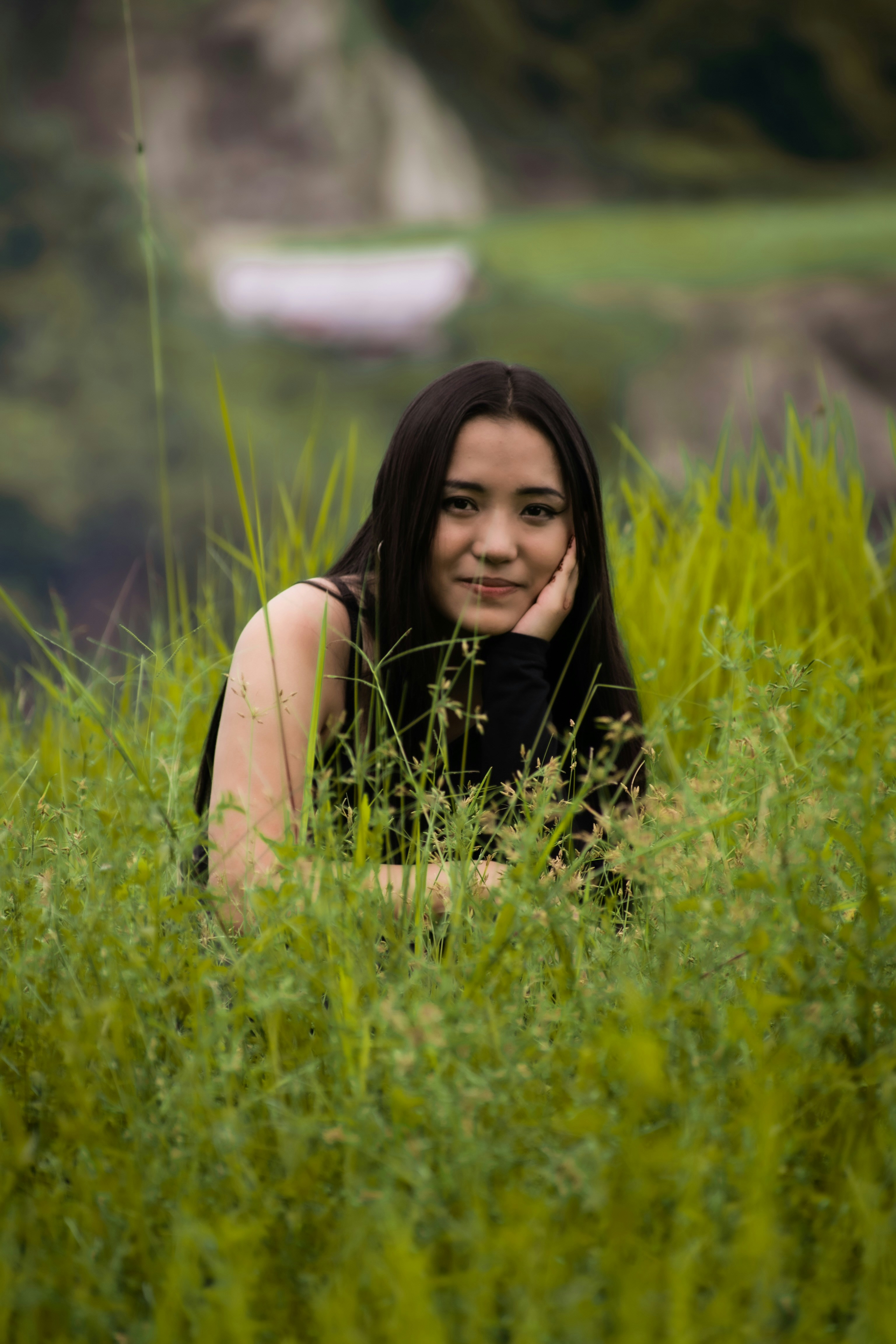 a woman sitting in a field of tall grass