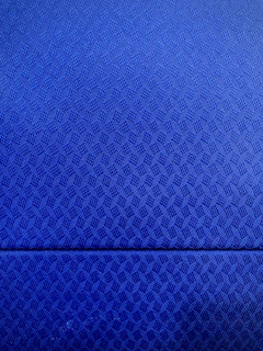 Close-up of a man’s formal shirt in a rich blue tone with a delicate geometric pattern inspired by Guatemalan textiles.