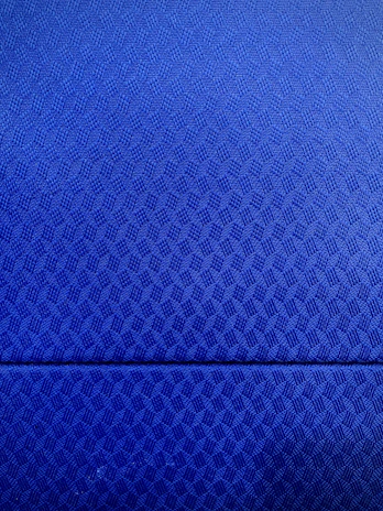 Close-up of a man’s formal shirt in a rich blue tone with a delicate geometric pattern inspired by Guatemalan textiles.