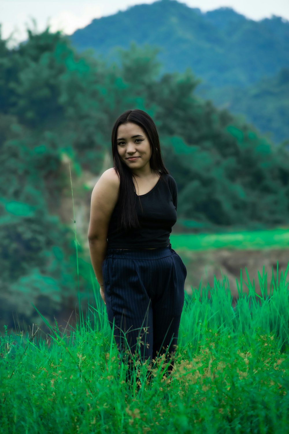 a woman standing in a field of tall grass