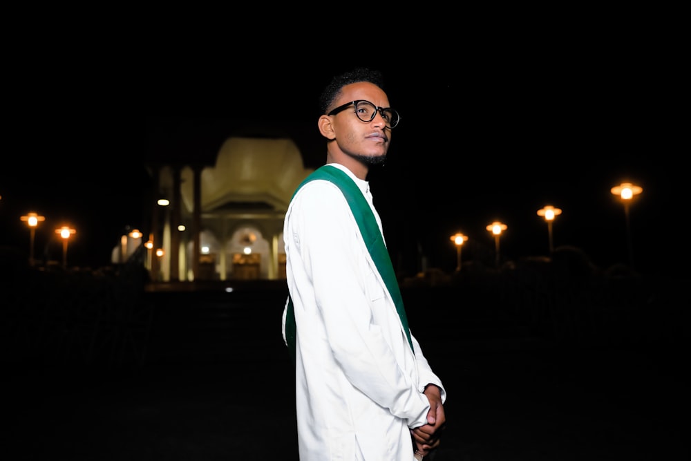 man in white robe wearing black framed eyeglasses