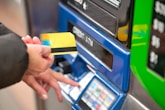 a person using a credit card to pay for a machine