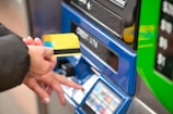 a person using a credit card to pay for a machine