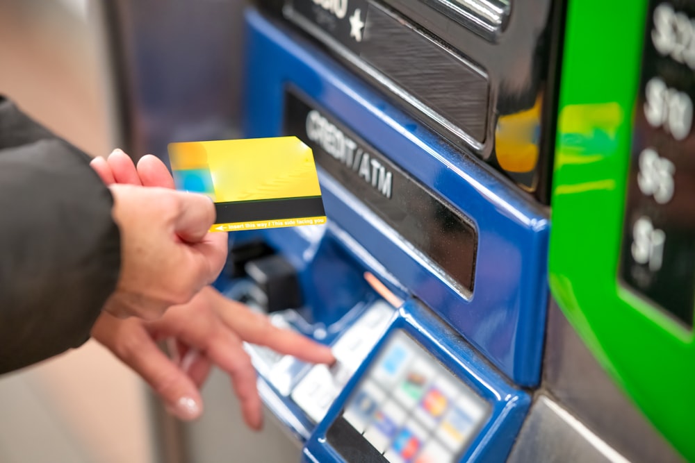 uma pessoa usando um cartão de crédito para pagar por uma máquina