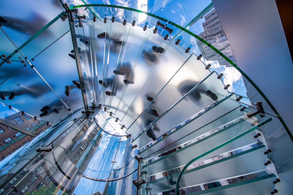 a spiral glass staircase with a sky background