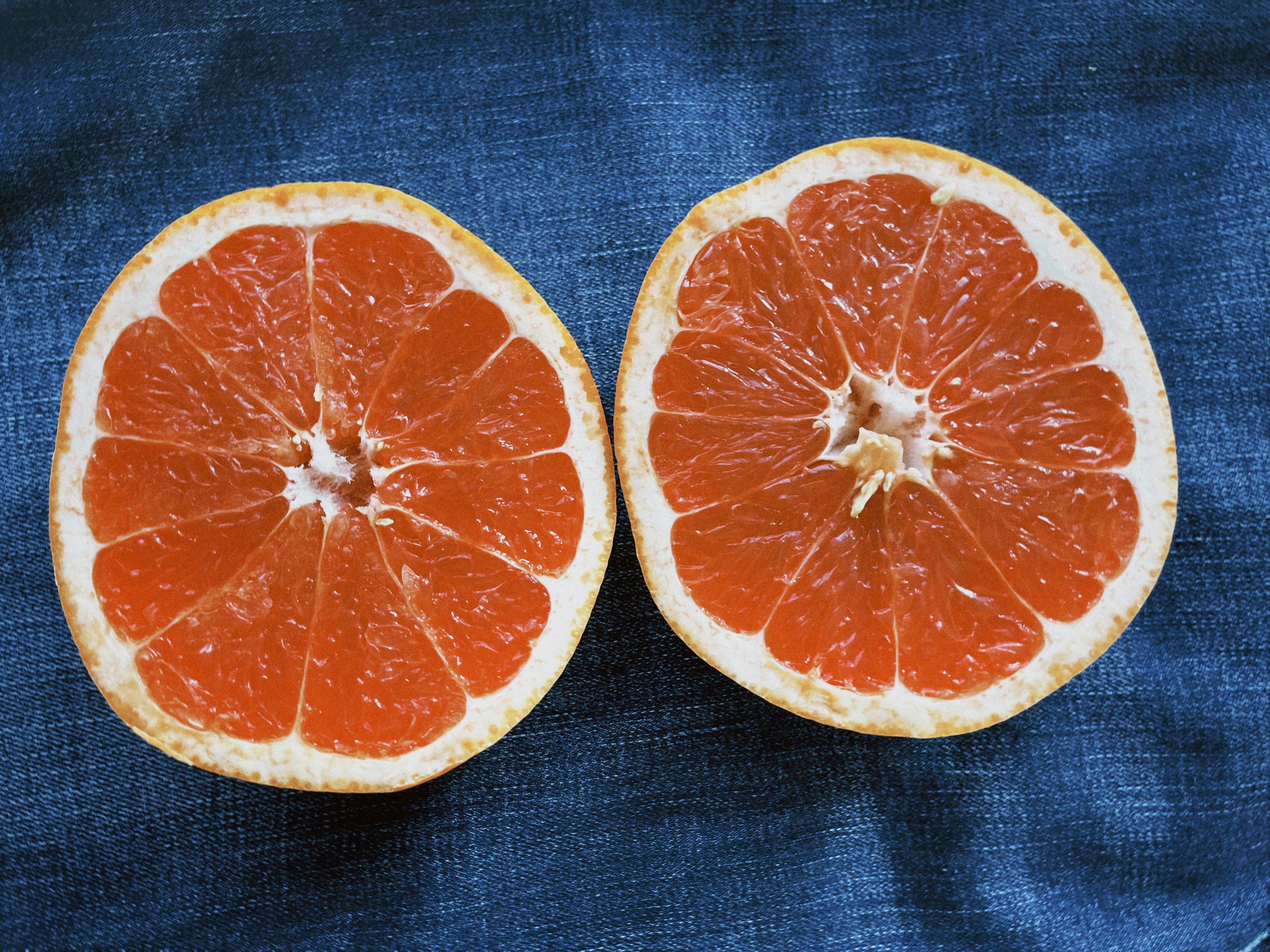 sliced orange fruit on blue textile