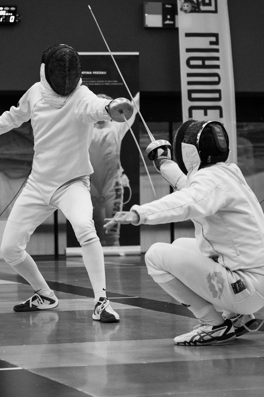 a couple of people on a court with fencing equipment