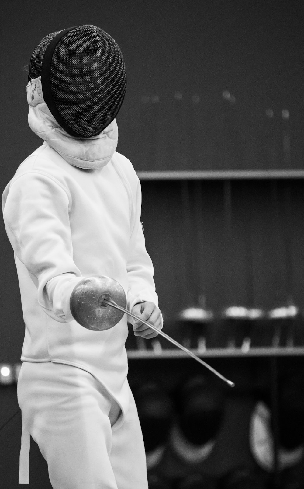 une personne en tenue blanche tenant un bâton