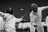 a couple of people that are standing up with fencing equipment