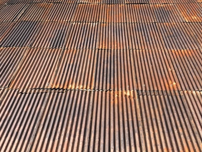 Close-up of metal roofing panels stacked in a workshop.