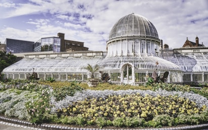 una meravigliosa serra di vetro immersa in un giardino di fiori e piante esotiche
