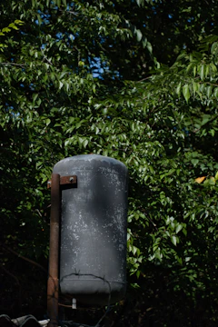 Technician cleaning and preparing an old underground oil tank for decommissioning.