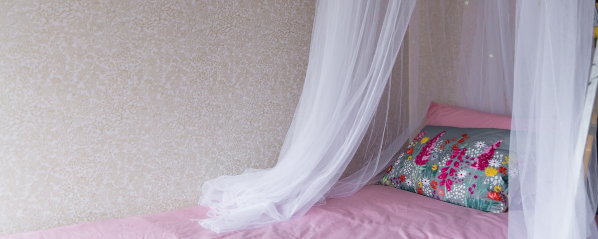 white textile on pink bed