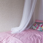 white textile on pink bed