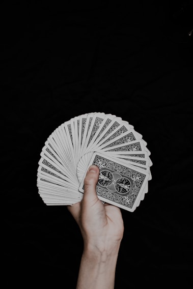 person holding white and black round hand fan