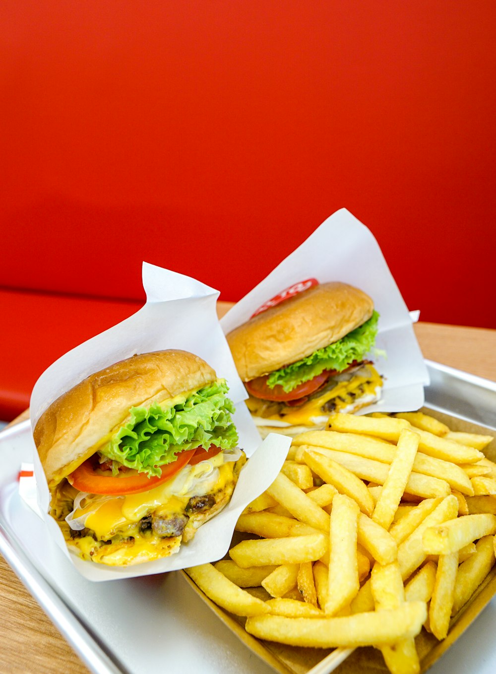 a tray with two sandwiches and fries on it