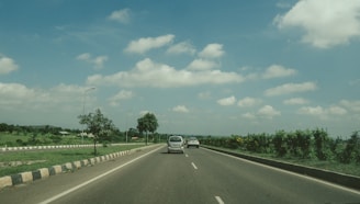 A scenic highway stretching between small towns under a clear sky.