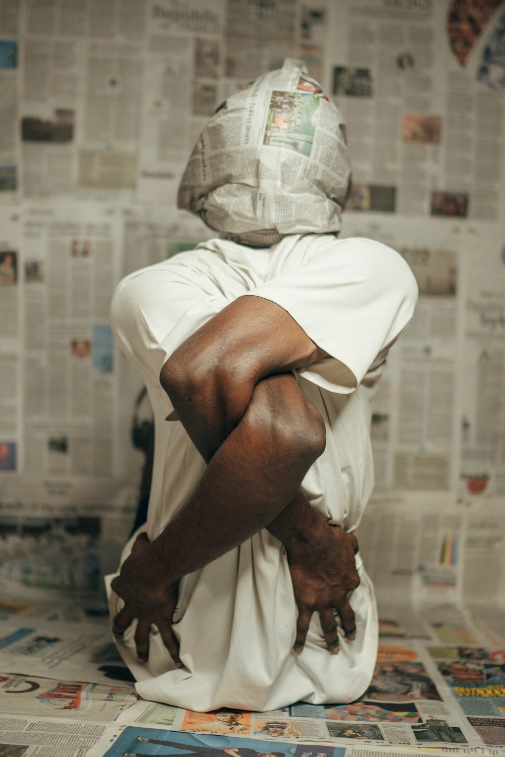 a person sitting on the ground with their hands on their knees