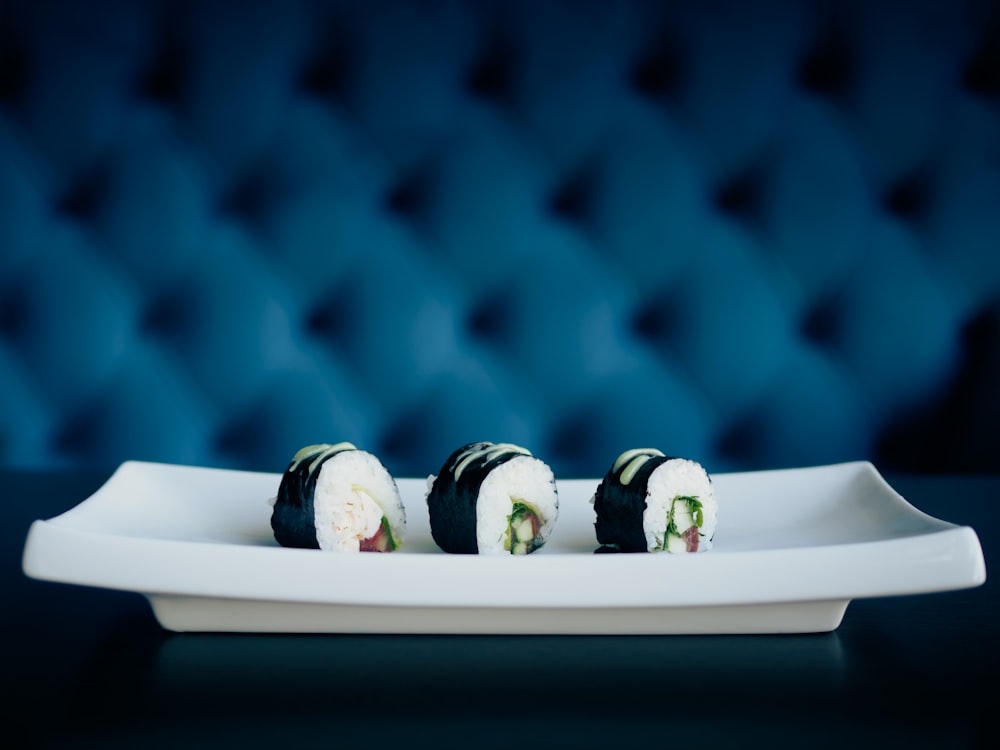 a white plate topped with sushi on top of a table