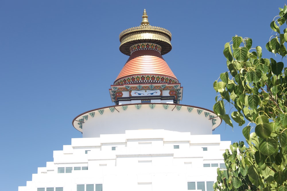 a white building with a red and gold top