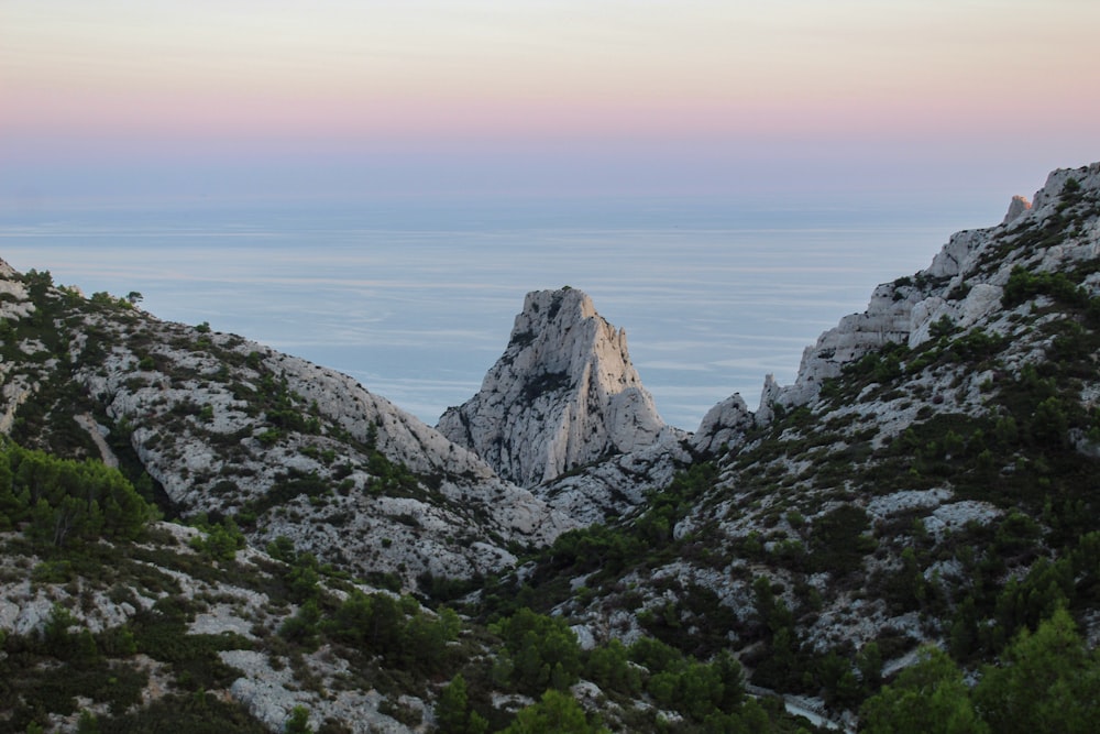 Una vista di una catena montuosa con un cielo rosa sullo sfondo