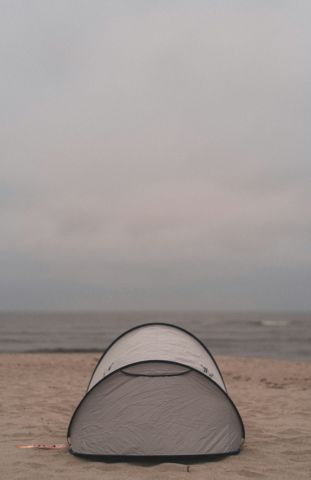 white tent on brown sand near sea during daytime