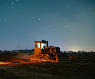 a bulldozer in the middle of a field at night