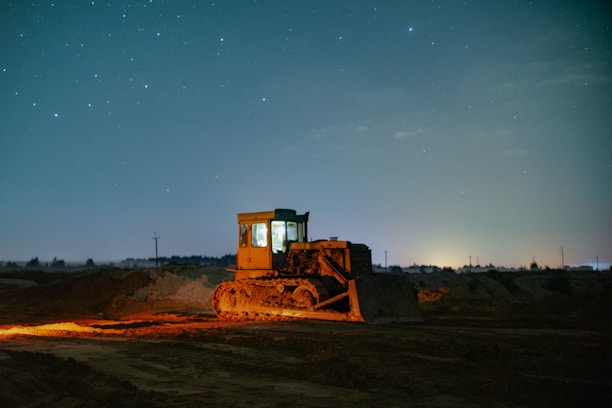 a bulldozer in the middle of a field at night