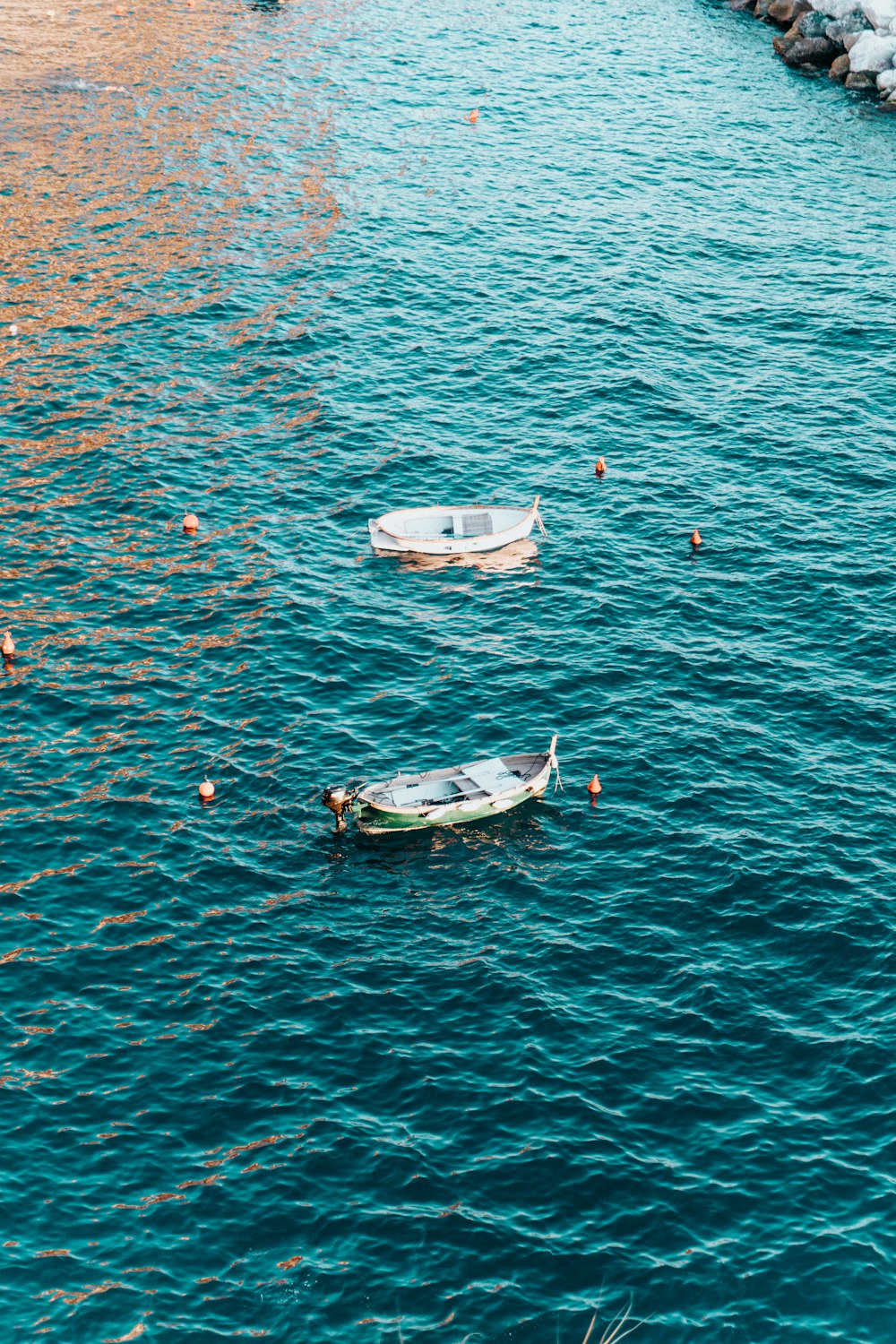 a couple of small boats floating on top of a body of water