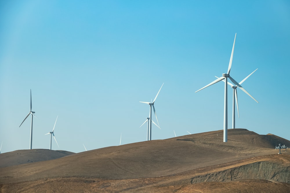 a group of wind turbines on a hill