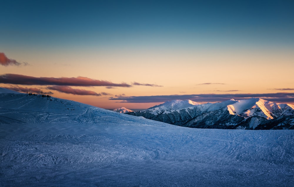 a snow covered mountain with a sunset in the background