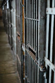 A close-up of a worn badge reflecting a distorted image of the prison yard.