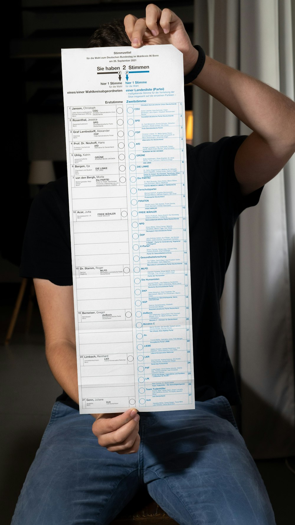 a man sitting on a chair holding up a paper