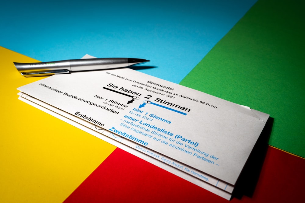 a close up of a pair of business cards and a pen