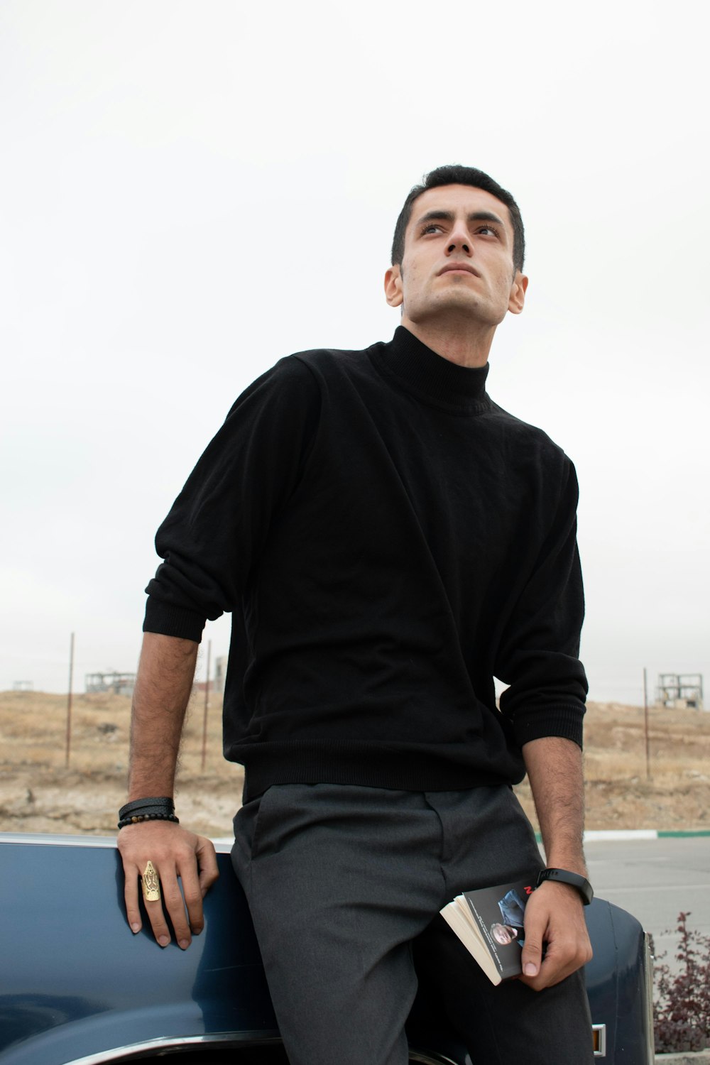 a man sitting on the hood of a car