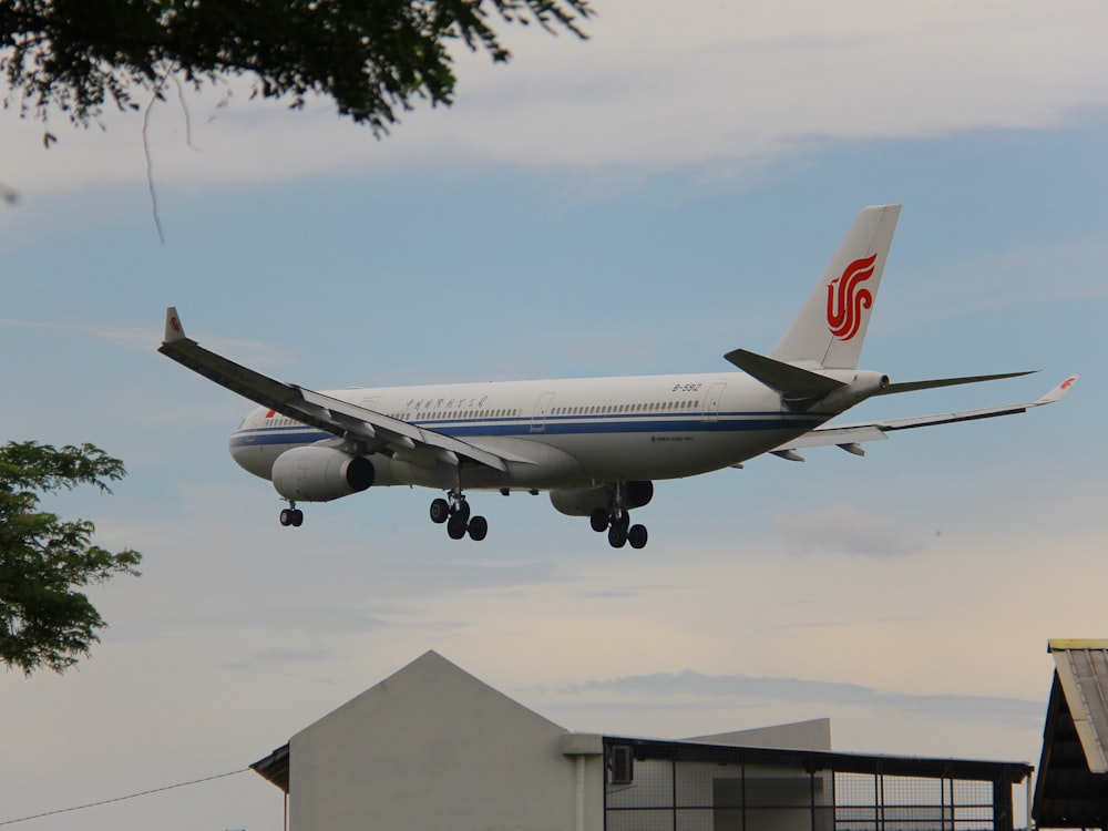 a large jetliner flying through a cloudy blue sky