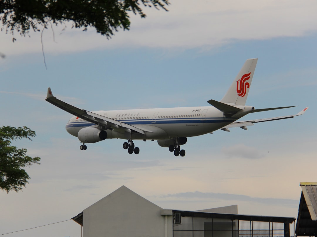 a large jetliner flying through a cloudy blue sky, Air China on final at Soekarno Hatta Jakarta (CGK) as CA701 arriving 