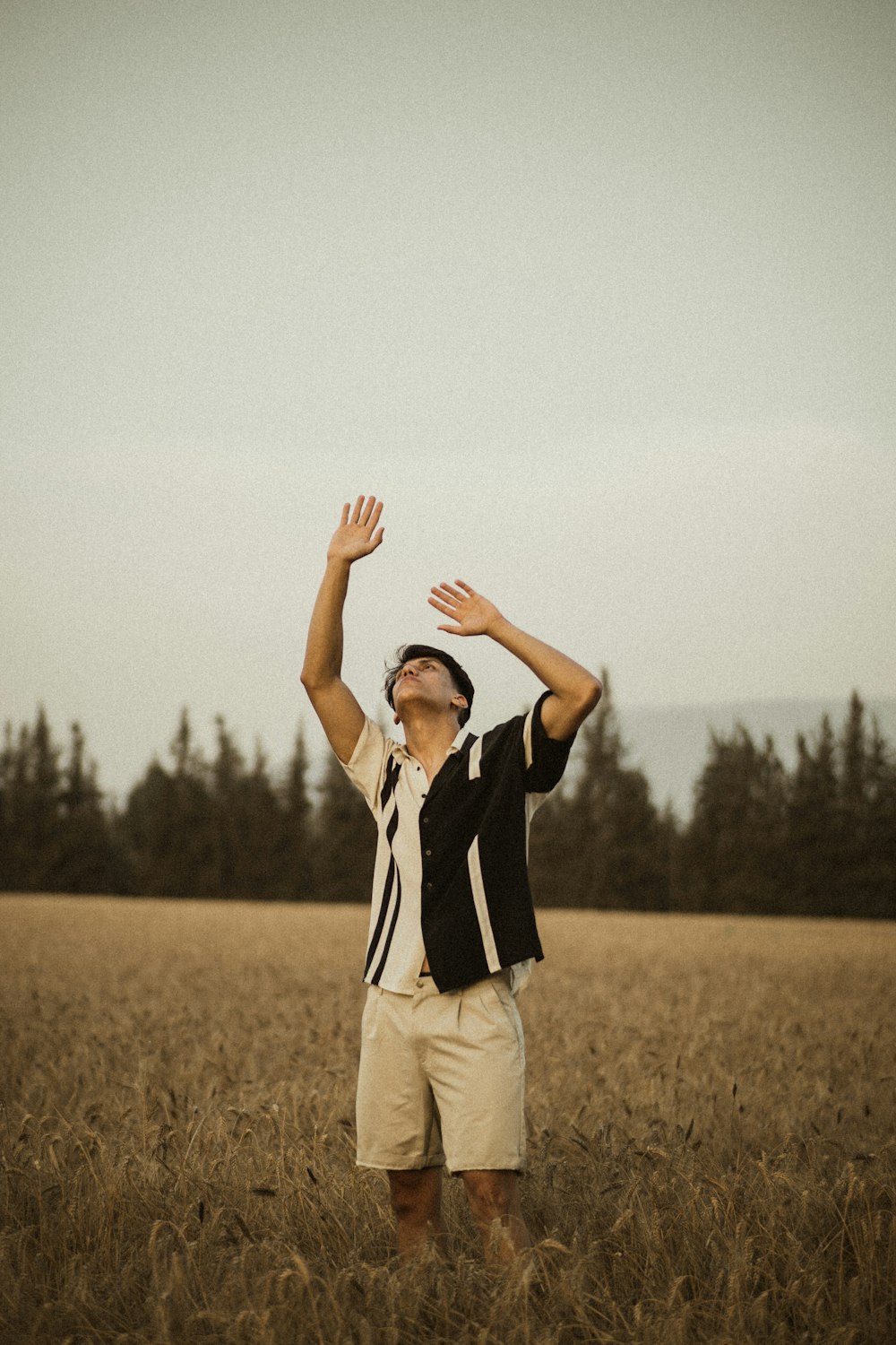 woman in black blazer and beige pants standing on brown grass field