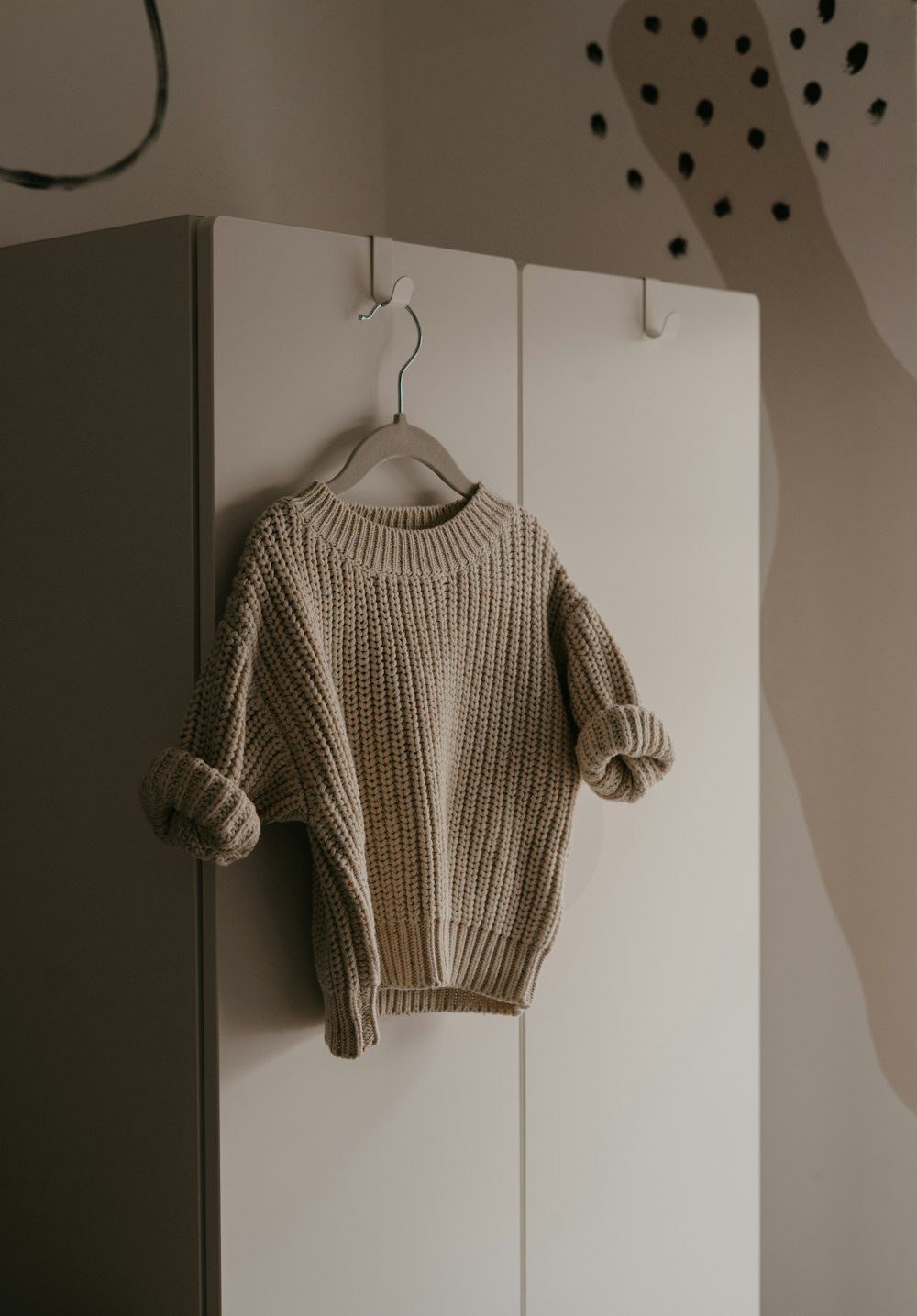 um suéter pendurado em um gancho em uma sala