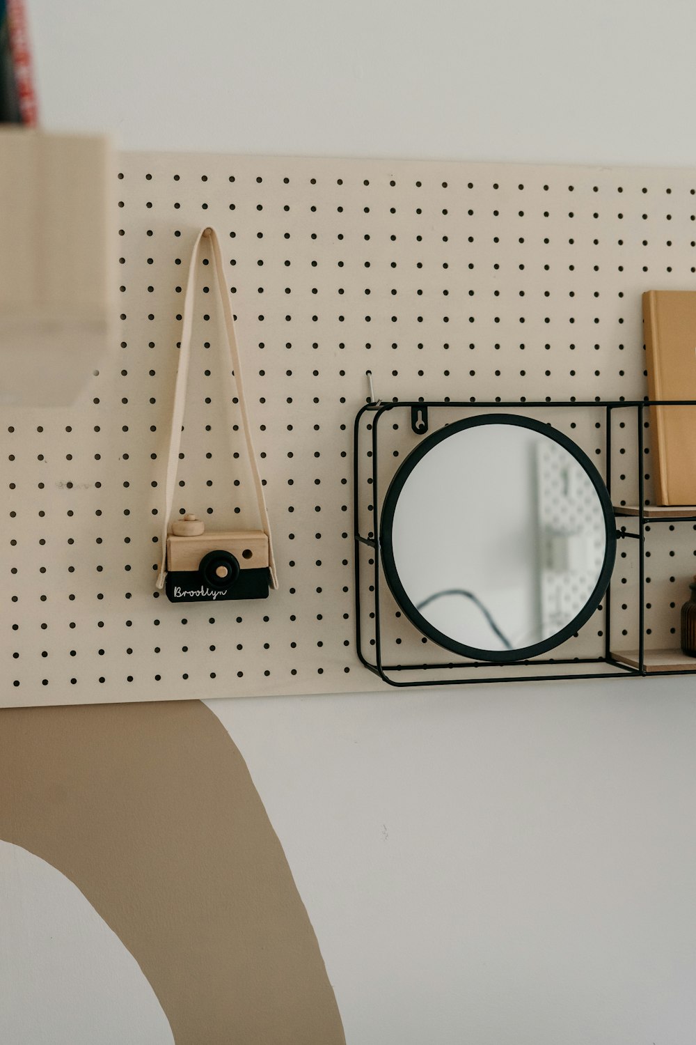 a wall mounted mirror and a shelf with a camera