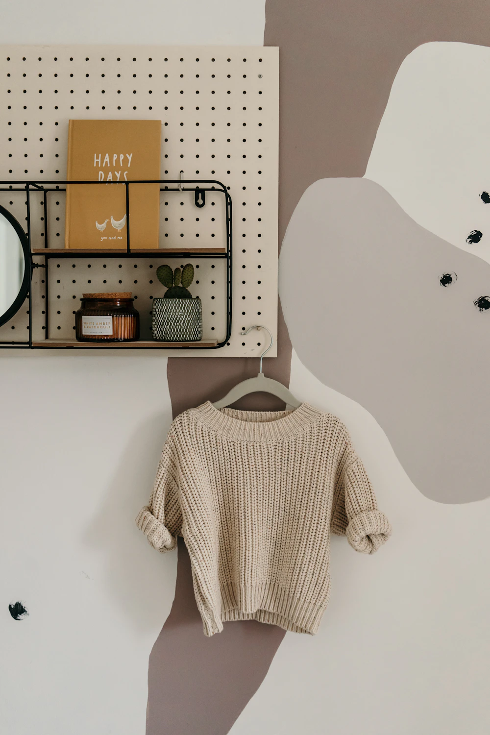 Tan chunky knit sweater hanging on a wardrobe hook