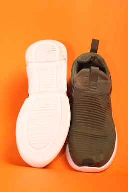 a pair of shoes sitting on top of an orange background