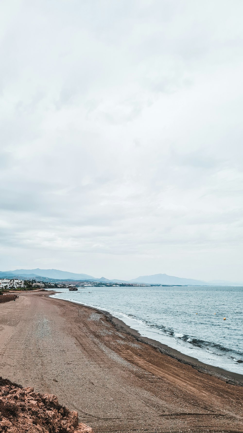 a sandy beach with a body of water in the background