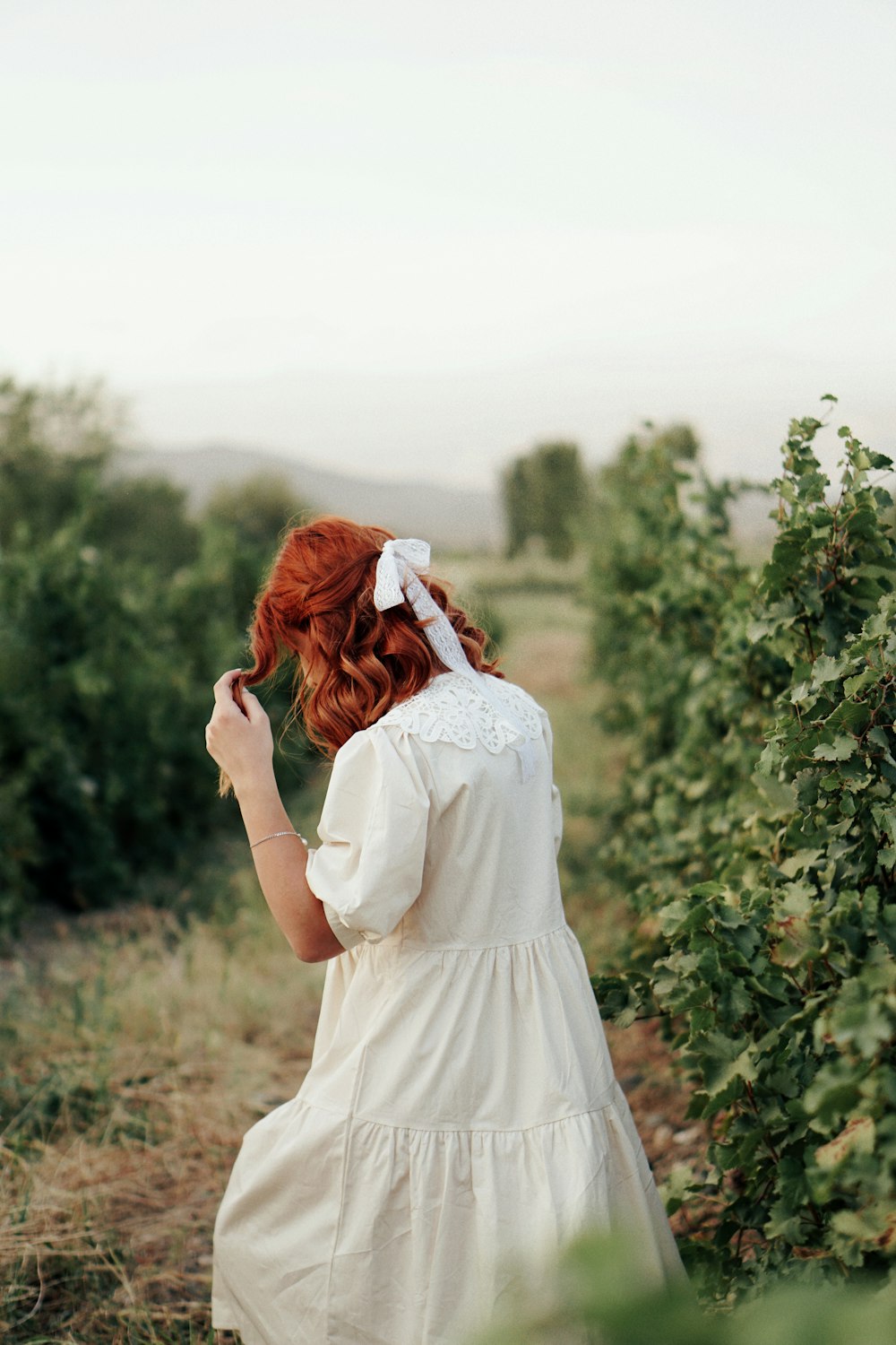 a woman in a white dress standing in a field