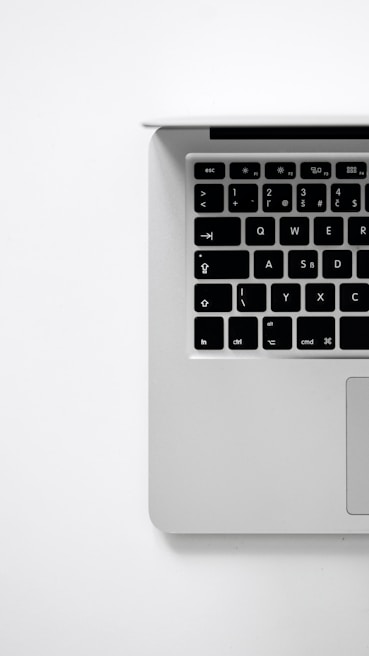 Close-up of hands typing on a minimalist keyboard with Google homepage on a laptop