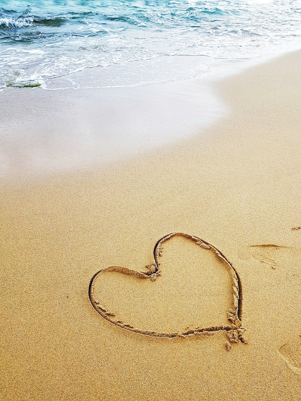 a heart drawn in the sand on a beach