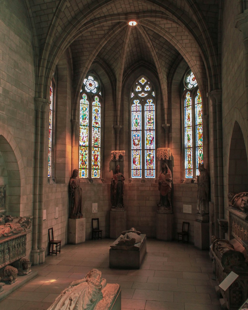a large room with stained glass windows and statues