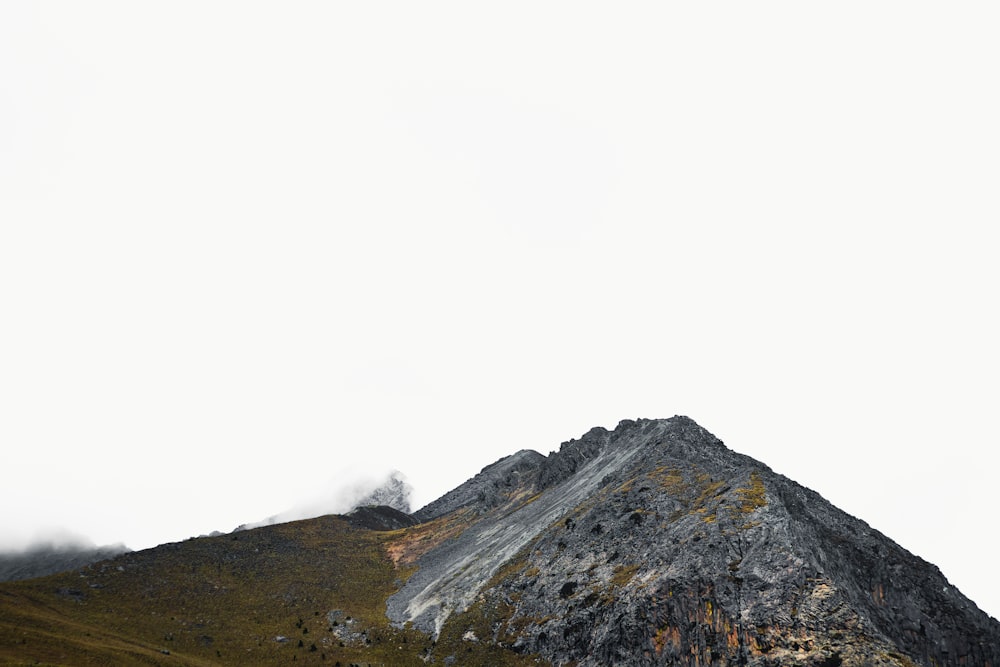 a very tall mountain with a few clouds in the sky