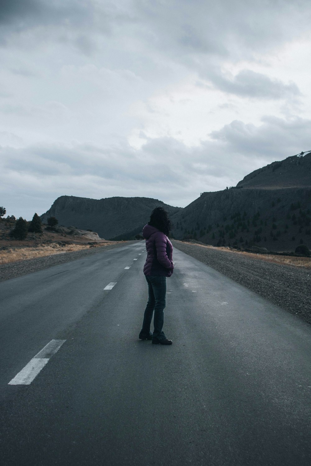 a woman standing in the middle of a road